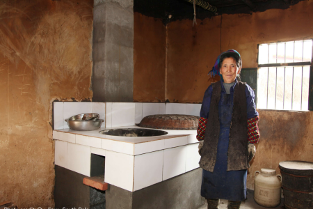 屋主站在新安装的省柴炉灶旁边。