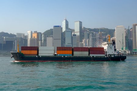 A river vessel with containers sails through Victoria Harbour in Hong Kong 