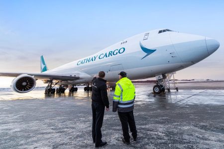 Cathay Cargo aircraft on runway with ground staff 