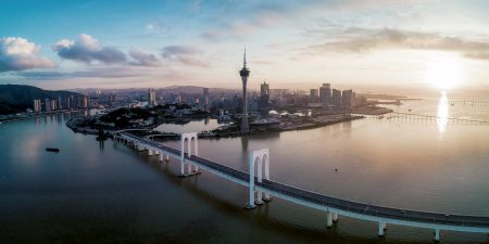 The Hong Kong-Zhuhai-Macao Bridge leading into Macao over water with the Macau Tower and skyline in background