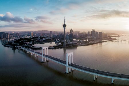The Hong Kong-Zhuhai-Macao Bridge leading into Macao over water with the Macau Tower and skyline in background