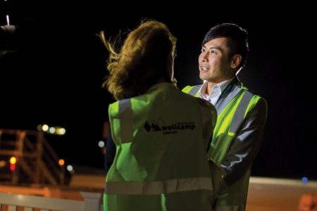Nelson Chin wearing safety vest on runway at night