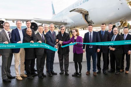 Governor Kate Brown cuts ribbon in group photo gathered around Cathay aircraft