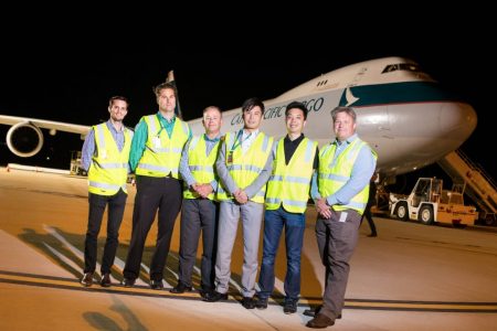 Nelson Chin, Nigel Chynoweth and others in front of Cathay aircraft at airport