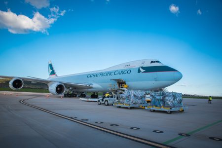 Cathay Cargo aircraft on tarmac with shipments outside