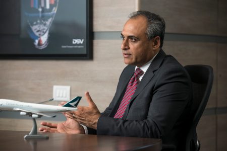 Sameer Khatri seated at desk with Cathay model aircraft