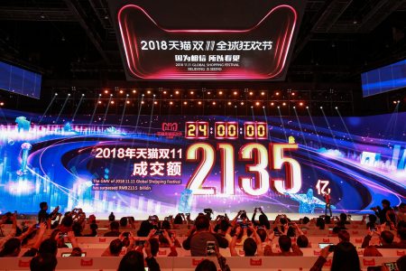 2018 Singles' day sales revenue of 213.5 billion RMB displayed onscreen at event, audience takes photos