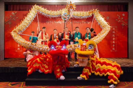 Cathay management team photo onstage at Chinese new year party with lion dancers