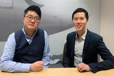 Alex Leung and John Cheng seated at a desk