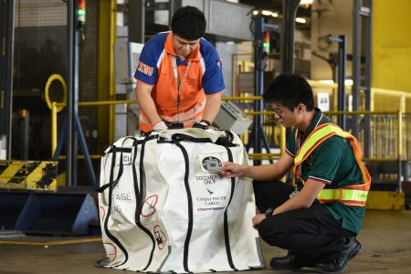 Ground staff inspecting fire containment bag