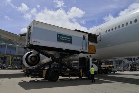 Catering truck raised on scissor lift to Cathay aircraft door