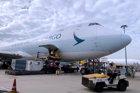 Cathay Cargo aircraft on tarmac being loaded with ULD's