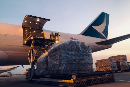 Cargo shipment being loaded onto Cathay Cargo aircraft at sunset