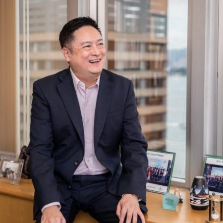Frank Lin, seated on office cabinet for candid photo