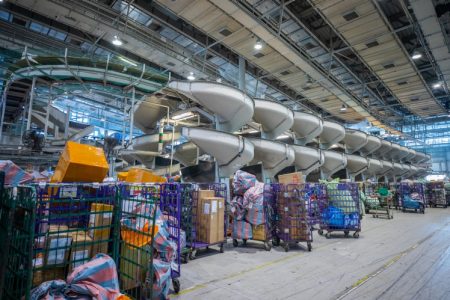 Industrial cargo bay with multiple secured containers and overhead equipment