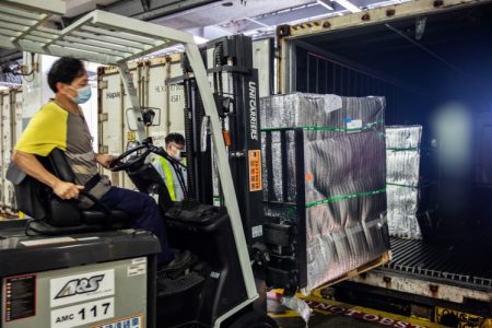 Forklift with operator, loading cargo into ULD