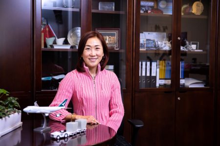 Jenny Lam at desk with model aircraft and baggage tractor