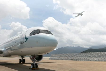 Airbus A321 Neo in Cathay livery on tarmac, with another Cathay aircraft visible in flight