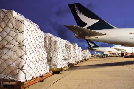 Rows of packed shipments and Cathay aircraft on tarmac