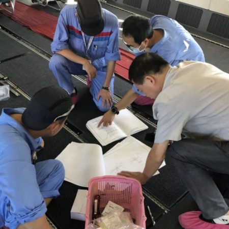 Technical crew confguring cabin, referring to document