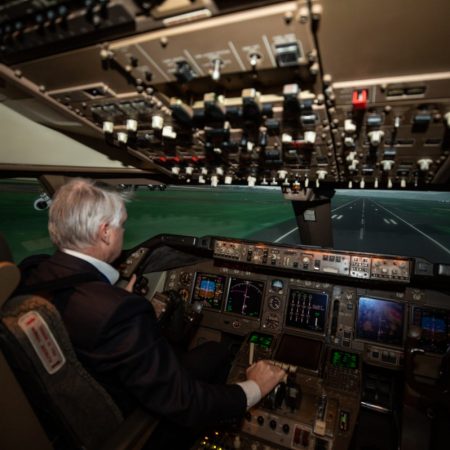 Pilot in flight sim cockpit landing on runway