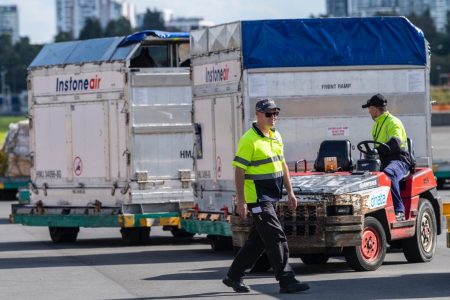 Live animal shipment containers transported on baggage tractor