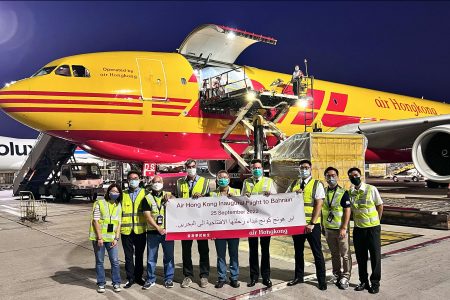 Air Hong Kong team posing with banner in front of  aircraft in DHL express livery