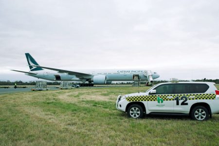 Cathay 777 in Hobart with airport car nearby