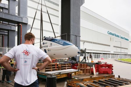 Rowing team member looking at boat component at cargo terminal