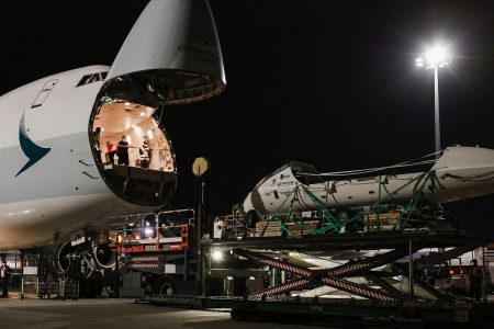 Boat on aerial platform in front of aircraft with nose cargo door open