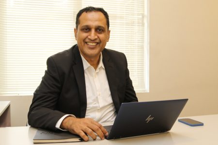 Irshad Razack seated at desk