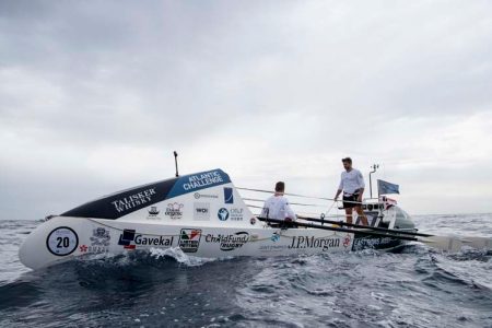 East Rows West boat at sea, with teammates rowing