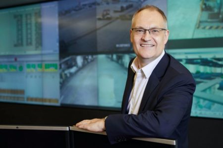 Mark Watts sitting in front of camera feed display