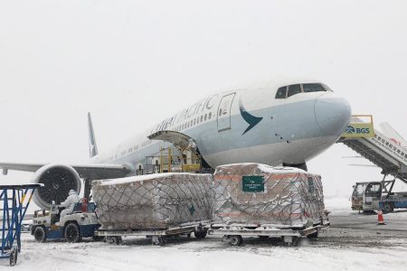A Cathay Pacific aircraft on a snow covered tarmac