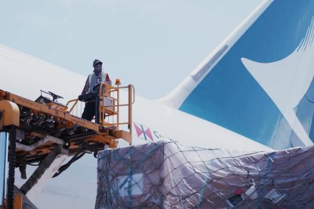 Crew standing on platform outside Cathay aircraft with shipments ready for loading