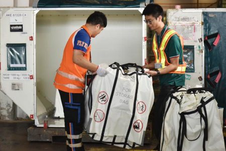 Baggage handlers holding fire containment bags