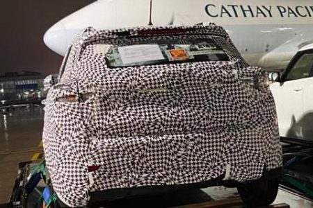 car wrapped in camouflage outside Cathay aircraft