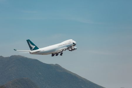 Cathay aircraft taking off, mountain in background