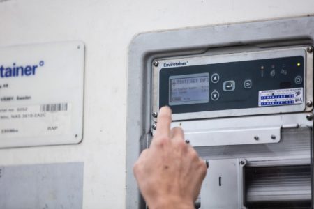 A hand in front of a cooltainer control panel