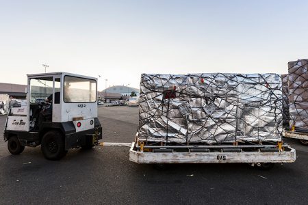 Insulated cargo shipment on pallet with baggage tractor