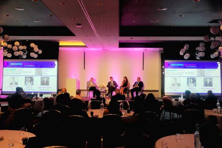 Panel discussion at conference with audience at dinner tables