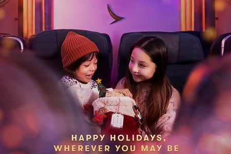 'Happy Holidays' image with children onboard Cathay flight holding Christmas stocking