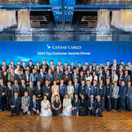 A large group of people gather in front of a banner that says Cathay Cargo 2024 Top Customer Awards Dinner