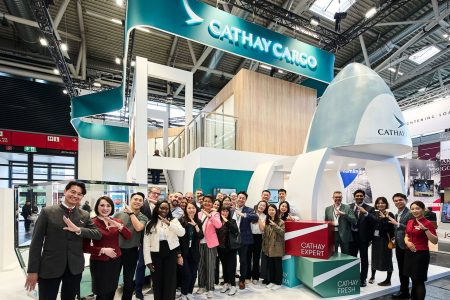 Cathay Pacific cabin crew and people gather on a Cathay Cargo exhibition stand