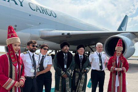 Cathay Cargo crew from the inaugural flight to Astana pose in front of a Cathay Cargo Boeing 747 freighter with a welcoming party in Kazakh traditional dress