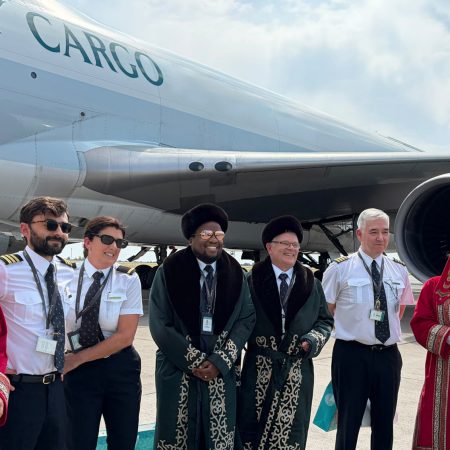 Cathay Cargo crew from the inaugural flight to Astana pose in front of a Cathay Cargo Boeing 747 freighter with a welcoming party in Kazakh traditional dress